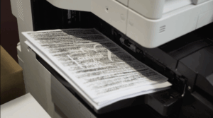EoaBM - 1 A screenshot of 'Echoes of a Better Me', showing a fax machine printing a paper with lettering.